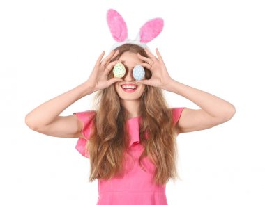 Paskalya yumurtaları ve beyaz arka plan üzerinde tavşan kulakları olan güzel kadın