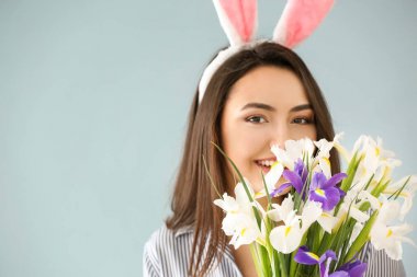 Paskalya bunny kulaklar ve buket çiçek renk arka plan üzerinde olan güzel kadın