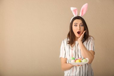 Paskalya yumurtaları ve tavşan kulakları renk arka plan üzerinde olan duygusal kadın