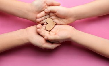 Anne ve çocuk renk arka plan üzerinde küçük ahşap kalpli