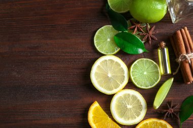 Şişe narenciye esans ve ahşap masa üzerinde meyve dilimleri ile