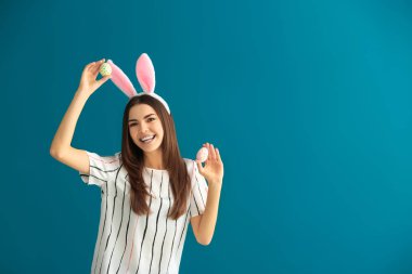 Paskalya yumurtaları ve tavşan kulakları renk arka plan üzerinde olan güzel kadın