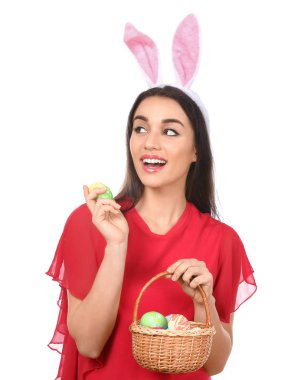 Paskalya yumurtaları ve beyaz arka plan üzerinde tavşan kulakları olan güzel kadın