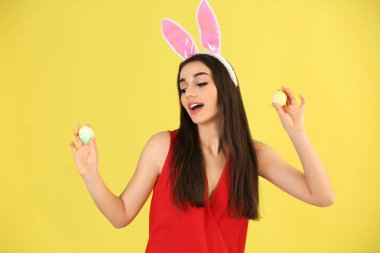 Paskalya yumurtaları ve tavşan kulakları renk arka plan üzerinde olan güzel kadın