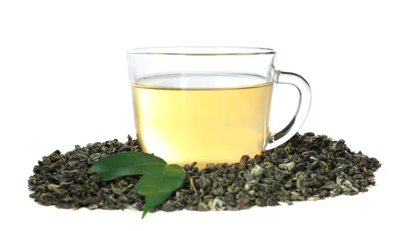 Hojas de té verde seco y taza de bebida aromática sobre fondo blanco — Foto de Stock