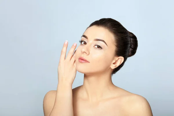 Mooie jonge vrouw met een zijdezachte huid na kuur op lichte achtergrond — Stockfoto