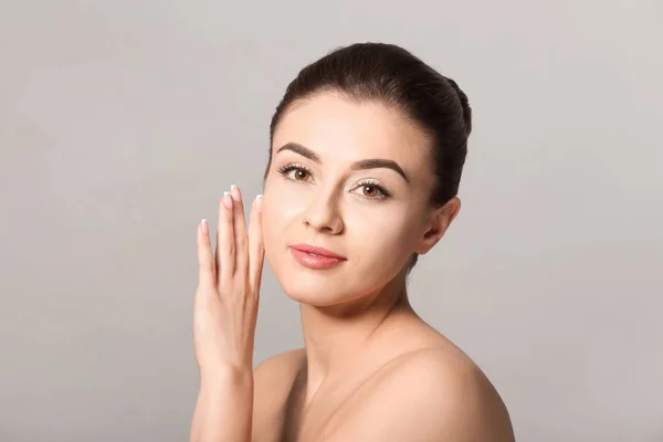 Vacker ung kvinna med silkeslen hud efter spa-behandling på ljus bakgrund — Stockfoto