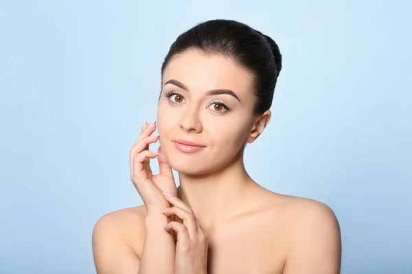 Vacker ung kvinna med silkeslen hud efter spa-behandling på färgbakgrund — Stockfoto