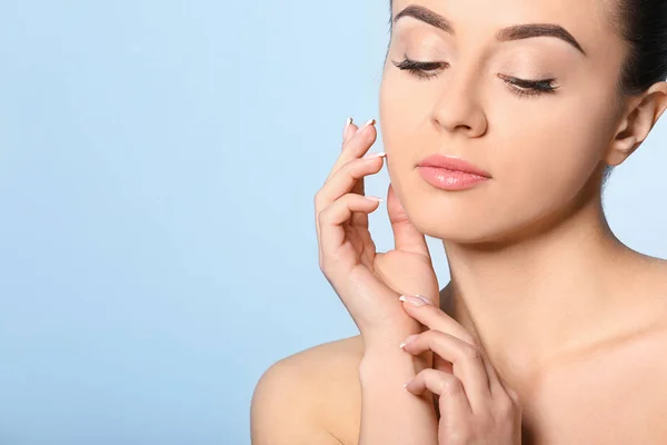 Mooie jonge vrouw met een zijdezachte huid na kuur op kleur achtergrond — Stockfoto