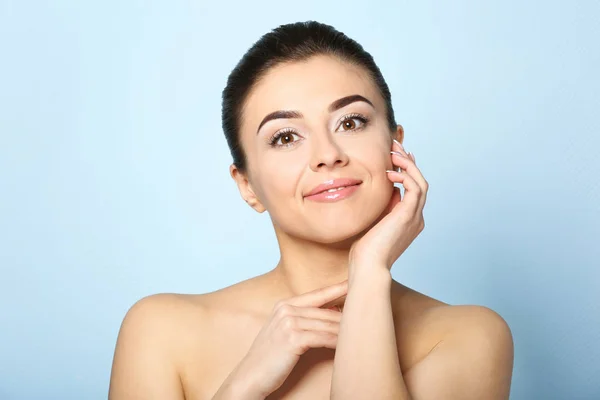 Beautiful young woman with silky skin after spa treatment on color background — Stock Photo, Image