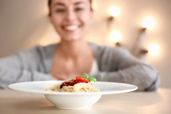 Placa con pasta sabrosa y mujer borrosa en el fondo —  Fotos de Stock