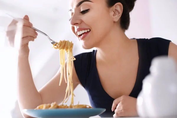 Mujer joven comiendo pasta sabrosa en el restaurante — Foto de Stock