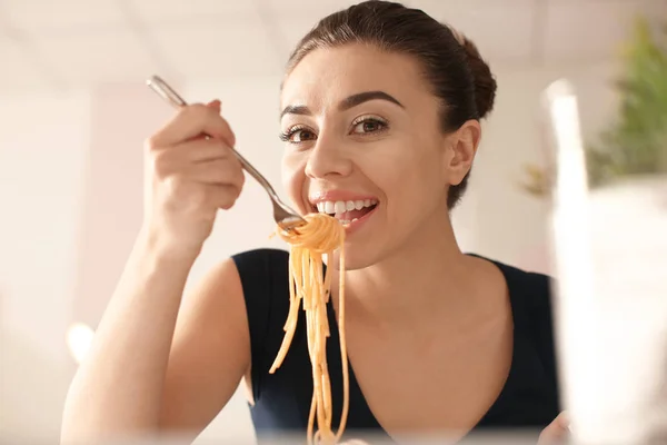 Mujer joven comiendo pasta sabrosa en el restaurante — Foto de Stock