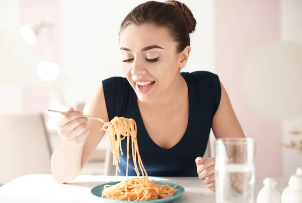 Mujer joven comiendo pasta sabrosa en la cafetería — Foto de Stock