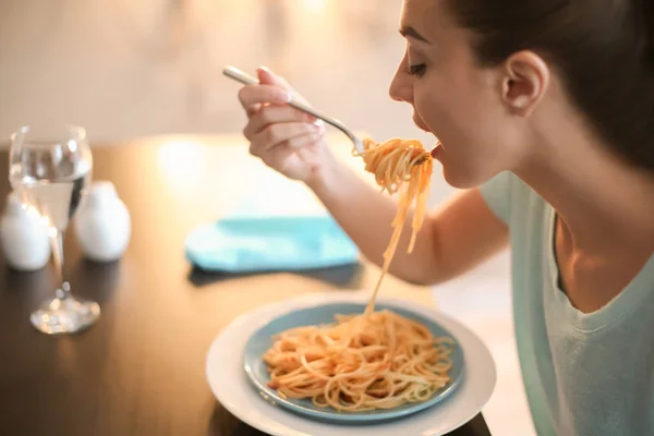 Jovem mulher comendo massa saborosa no café — Fotografia de Stock