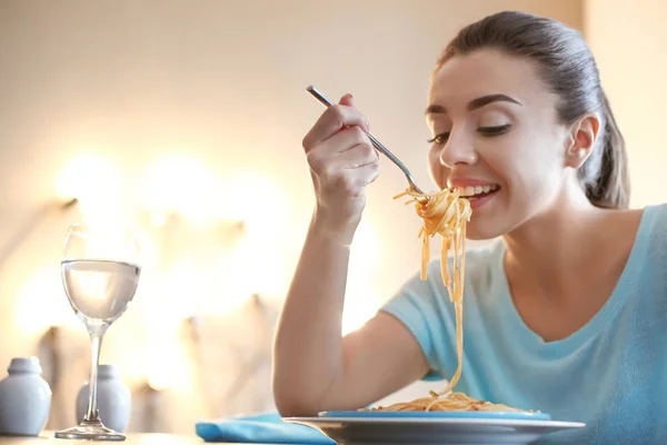 Young woman eating tasty pasta in cafe — Stock Photo, Image