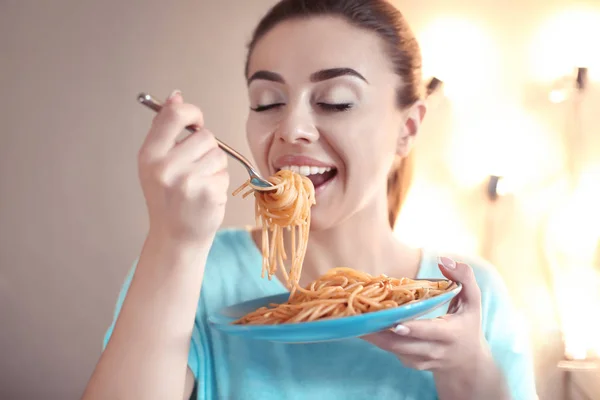 Young woman eating tasty pasta in cafe — Stock Photo, Image