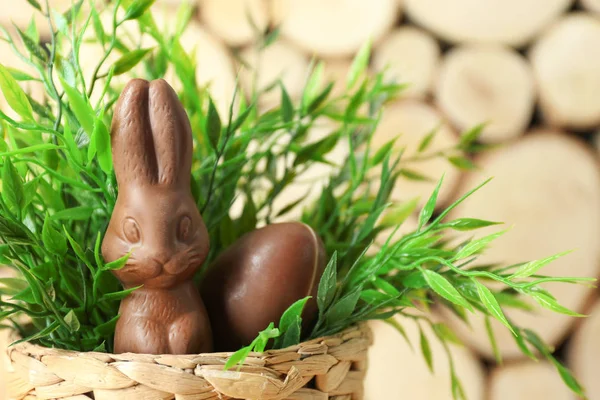Basket with chocolate Easter bunny and egg on blurred background — Stock Photo, Image