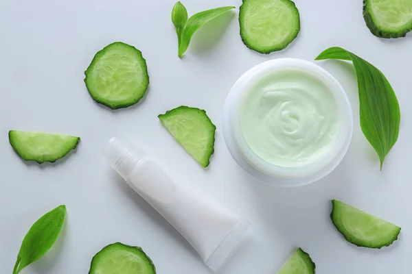 Composition with body cream and cucumber slices on white background — Stock Photo, Image
