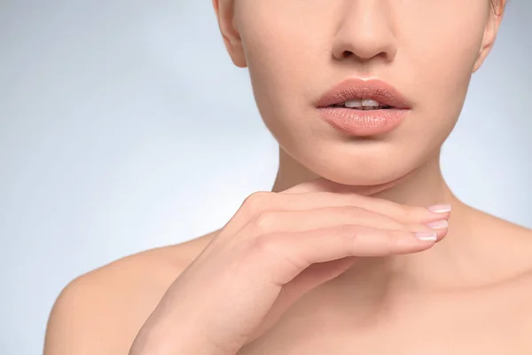 Hermosa mujer joven con maquillaje natural sobre fondo claro, primer plano —  Fotos de Stock