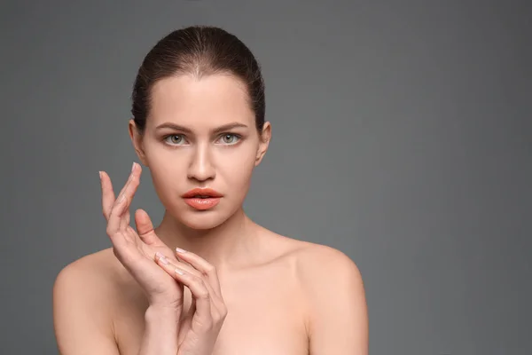 Beautiful young woman with natural makeup on grey background — Stock Photo, Image