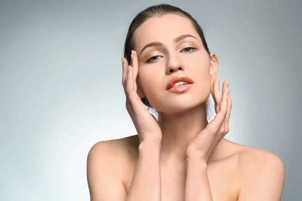 Hermosa mujer joven con maquillaje natural sobre fondo claro — Foto de Stock