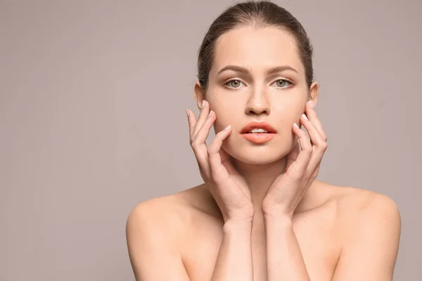 Mooie jonge vrouw met natuurlijke make-up op kleur achtergrond — Stockfoto