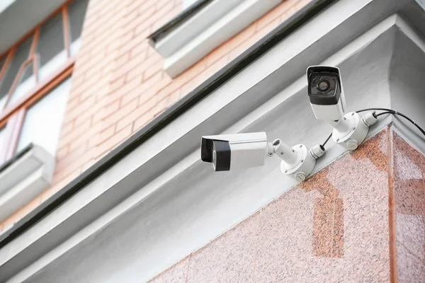 Modern CCTV cameras on wall of building outdoors — Stock Photo, Image