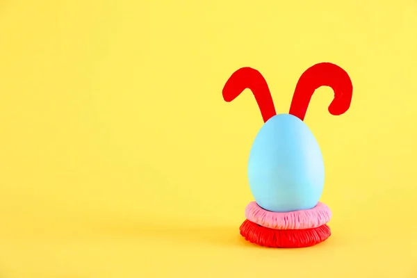 色の背景にウサギの耳で飾られたイースターエッグ — ストック写真