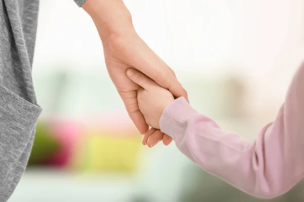 Madre y su hijita cogidas de la mano sobre un fondo borroso — Foto de Stock