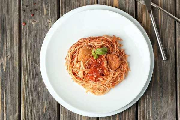 Deska z lahodné těstoviny s rajčatovou omáčkou na stole — Stock fotografie