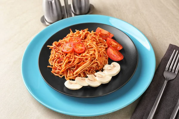 Plate of delicious pasta with tomato sauce on table — Stock Photo, Image