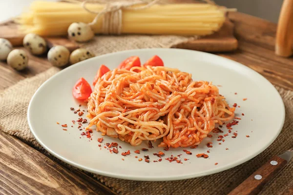 Тарелка вкусной пасты с томатным соусом на столе — стоковое фото
