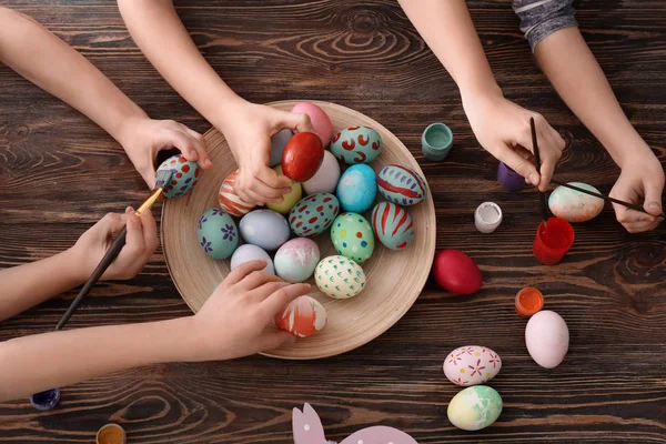 Χαριτωμένα μικρά παιδιά ζωγραφική αυγά για το Πάσχα στο τραπέζι — Φωτογραφία Αρχείου