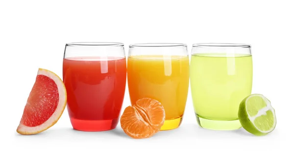 Glasses with different citrus juices and sliced fruits on white background — Stock Photo, Image