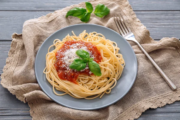 Plate of delicious pasta with tomato sauce and cheese on table — Stock Photo, Image