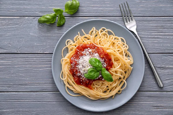Plate of delicious pasta with tomato sauce and cheese on table — Stock Photo, Image