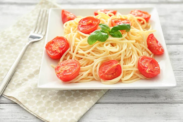 Тарілка смачної пасти з помідорами на столі — стокове фото