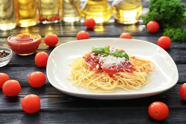 Plate of delicious pasta with tomato sauce and cheese on table — Stock Photo, Image