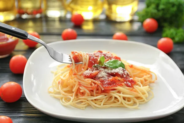 Delicious pasta with tomato sauce on fork over plate — Stock Photo, Image