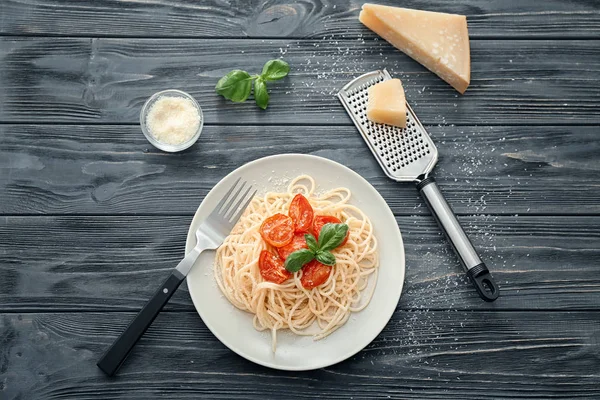 Plate of delicious pasta with tomatoes and cheese on table — Stock Photo, Image
