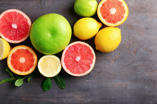 Composition with fresh citrus fruits on grey background, top view