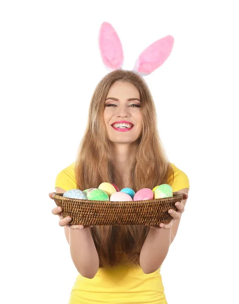 Όμορφη νεαρή γυναίκα με Πασχαλινά αυγά και bunny αυτιά σε λευκό φόντο — Φωτογραφία Αρχείου