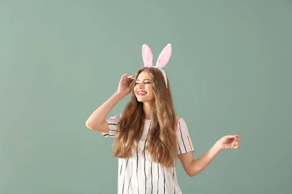 Mooie jonge vrouw met Easter bunny oren op kleur achtergrond — Stockfoto