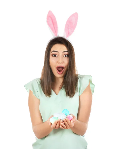 Emotional young woman with Easter eggs and bunny ears on white background — Stock Photo, Image