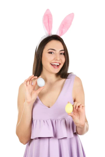 Belle jeune femme avec des œufs de Pâques et des oreilles de lapin sur fond blanc — Photo
