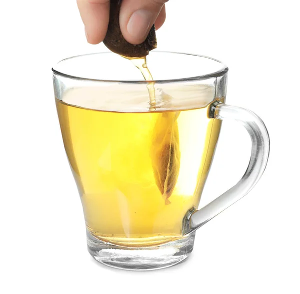 Brewing of hot beverage in glass cup using teabag, on white background — Stock Photo, Image