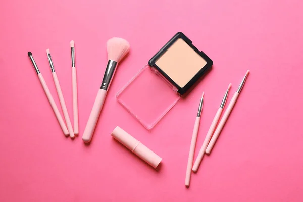 Dekorativní kosmetiku a kartáče pro použití make-up na barvu pozadí, pohled shora — Stock fotografie