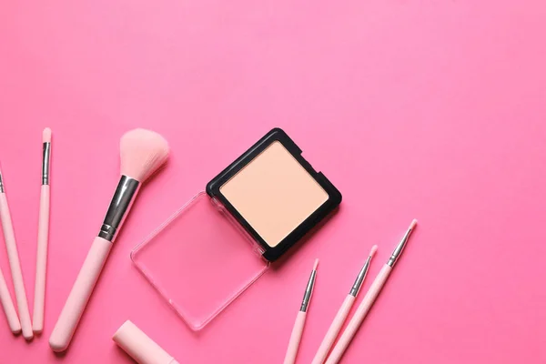 Face powder and brushes for applying makeup on color background, top view — Stock Photo, Image