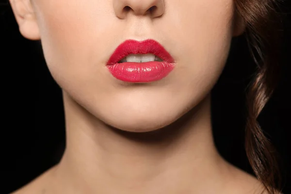 Schöne junge Frau mit hellem Lippenstift auf dunklem Hintergrund, Nahaufnahme — Stockfoto